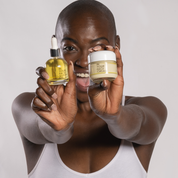 young black woman holding the OIL and CREAM
