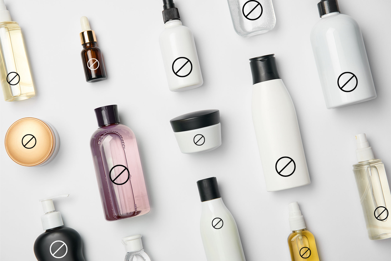 an image of cosmetic bottles laying flat on a white surface with the "no" symbol on the bottles