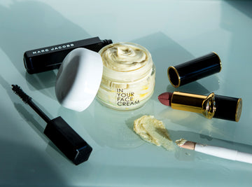 THE CREAM surrounded by luxury makeup products