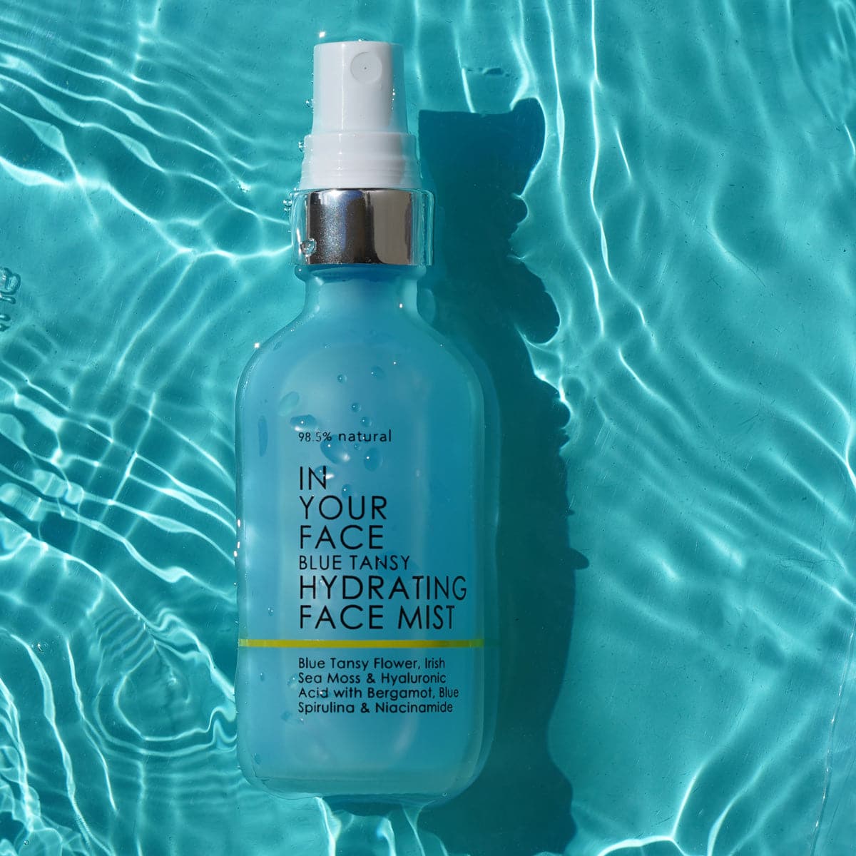 bottle of BLUE TANSY HYDRATING MIST floating in water
