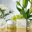 image of CAFFEINE LIFT EYE CREAM with orchids on reflective surface