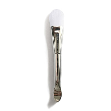 an image of the IN YOUR FACE MASK BRUSH on a white background. It's a silver color with white bristles.