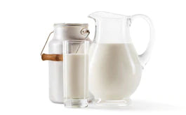 jug of milk and glass of milk on white background