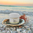 jar of the MARINE PEARL CREAM on the beach inside a shell