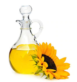 a carafe of vegetable oil with a sunflower next to it