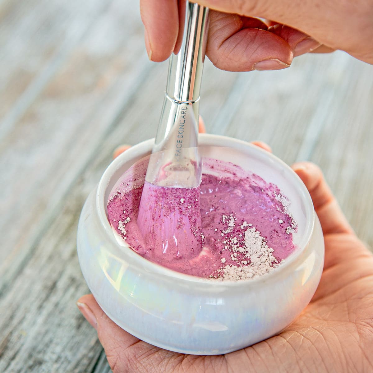 a photo of the IN YOUR FACE BOWL with a powder mask being turned into a pink liquid with our MASK BRUSK inside, stirring the liquid.