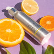 BODY OIL laying flat on a purple background