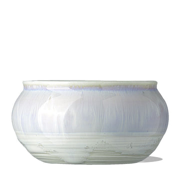 a clean shot of the IN YOUR FACE BOWL, a porcelain, artisan-made ceramic treatment bowl. It is an iridescent white color.