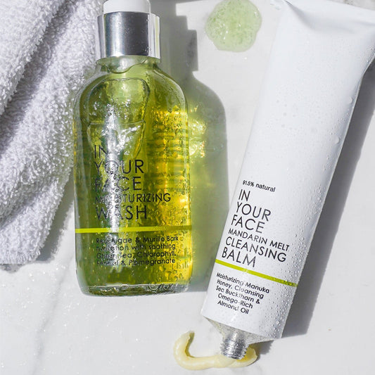 the DOUBLE CLEANSE DUO next to a towel on marble.