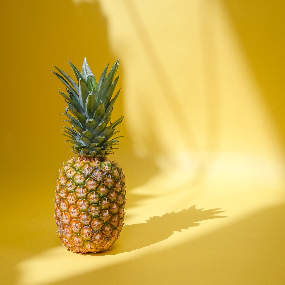 a whole pineapple on a yellow background