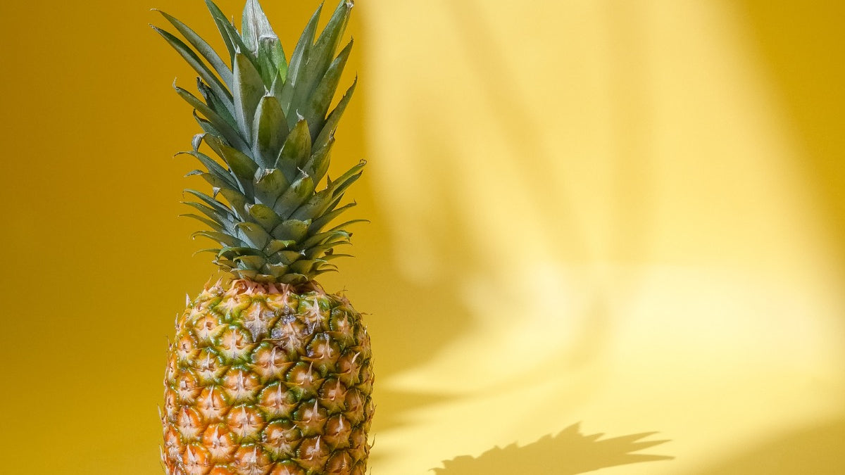 a whole pineapple on a yellow background
