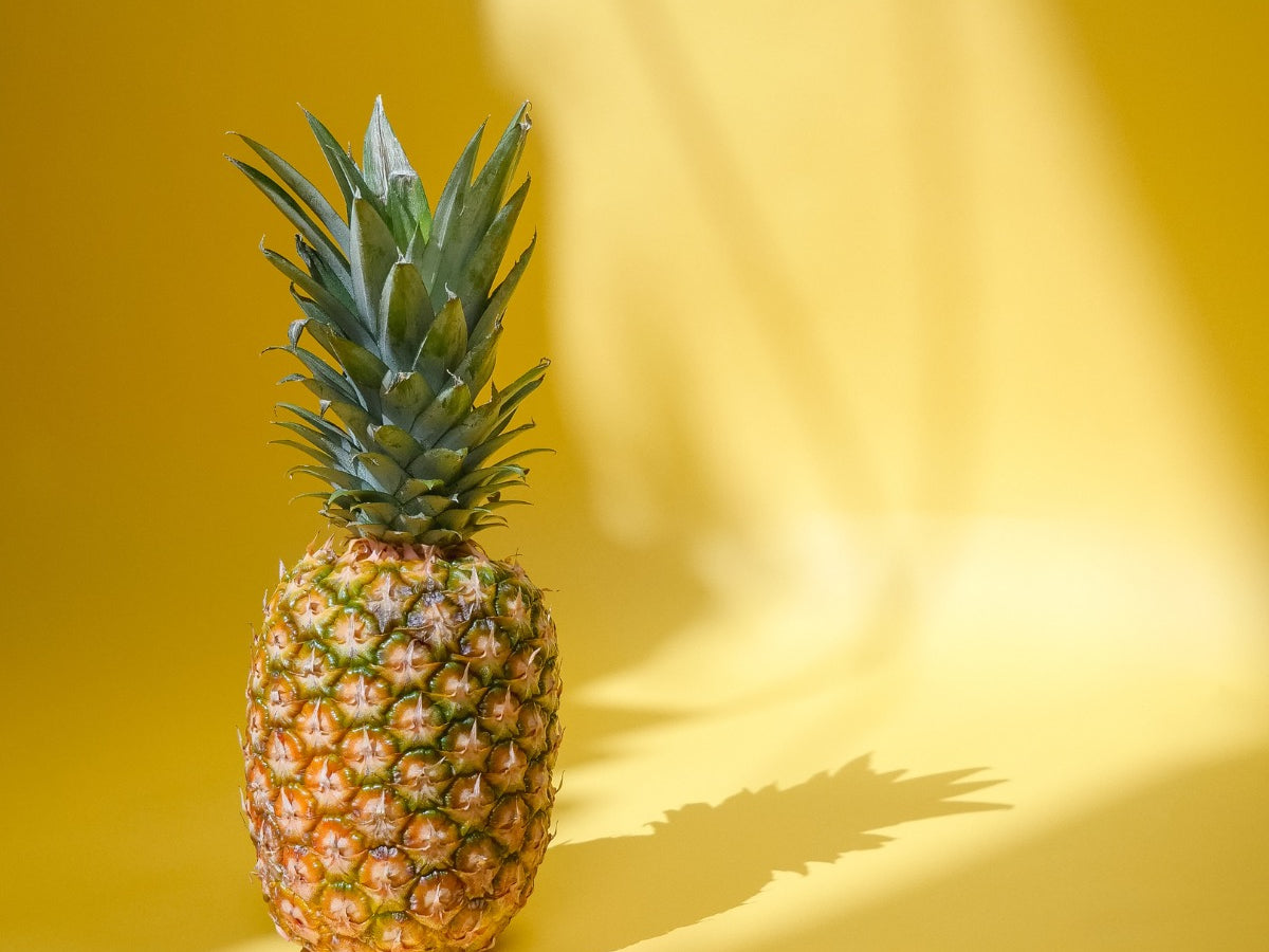 a whole pineapple on a yellow background