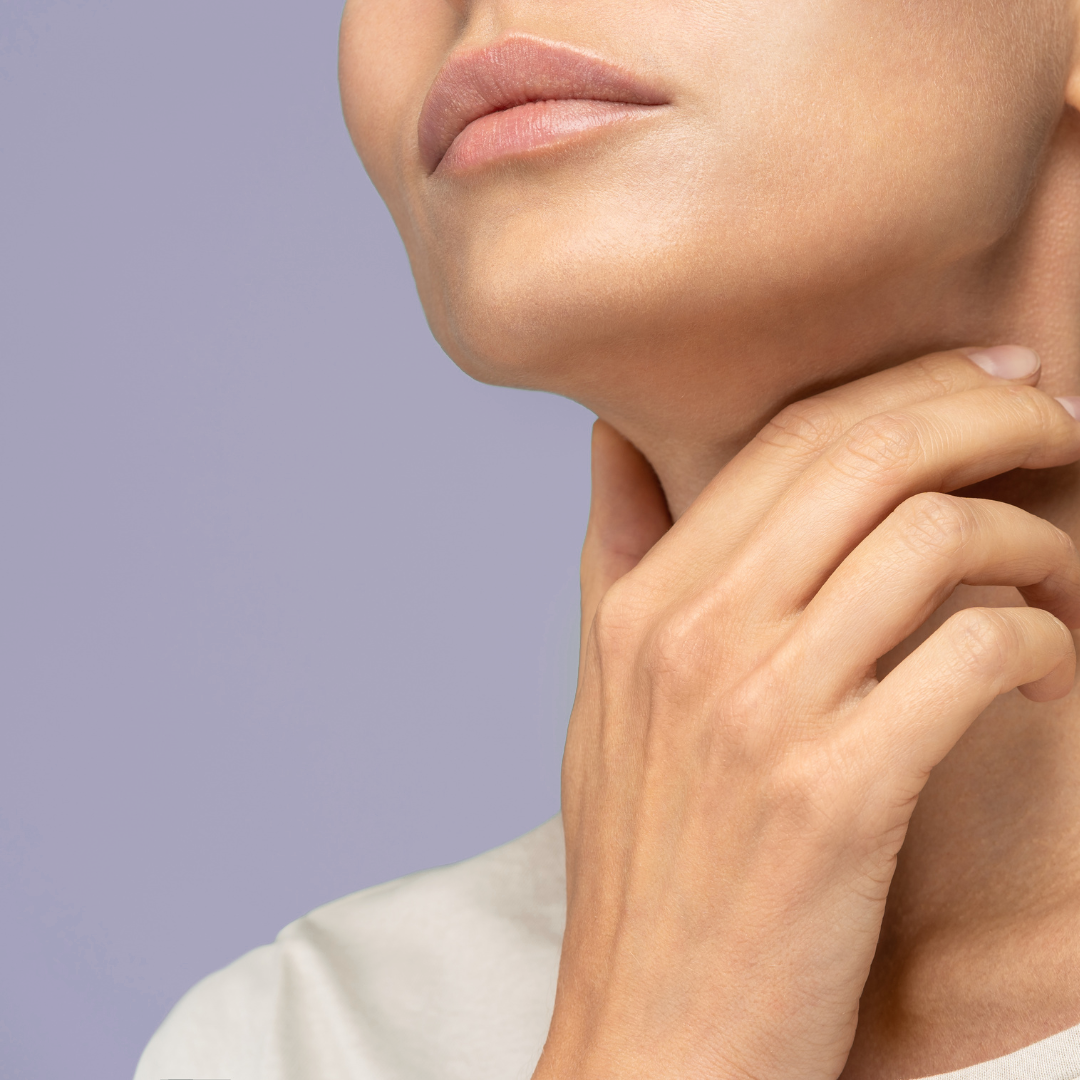 a woman holding her neck on a purple background
