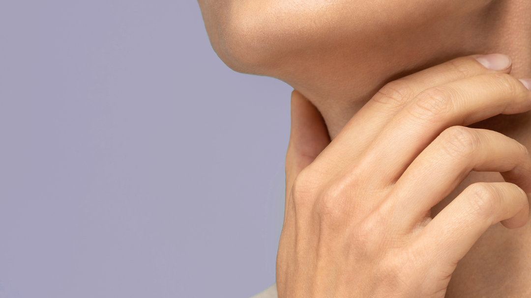 a woman holding her neck on a purple background