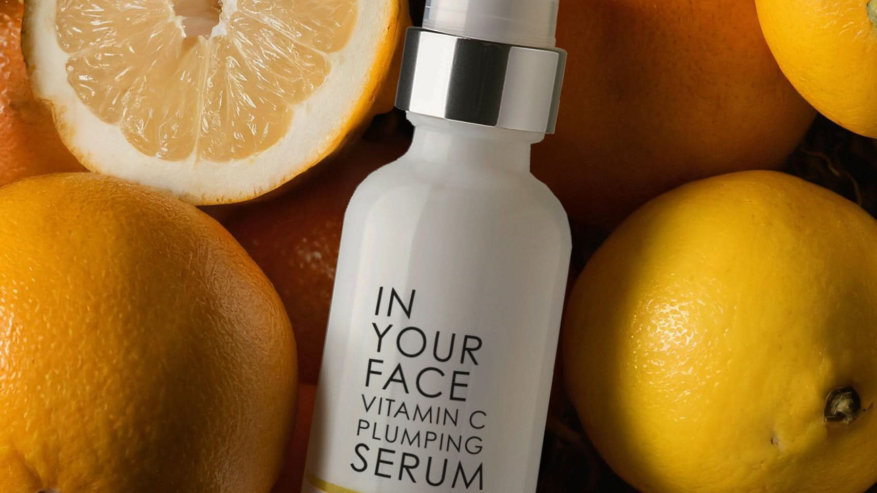 photo of VITAMIN C PLUMPING SERUM jar laying on oranges