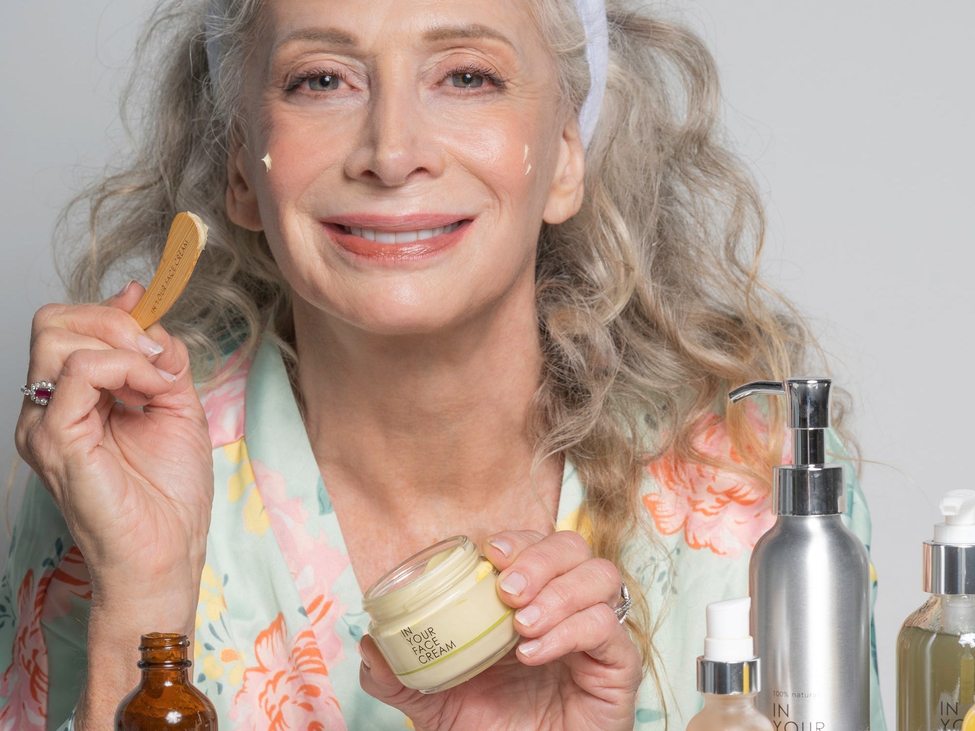 a mature woman applying CREAM and smiling