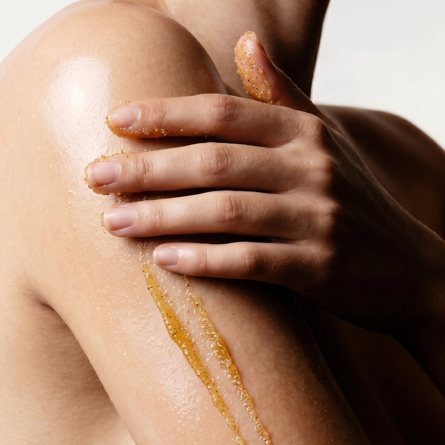 woman applying EXFOLIATING GLOW BODY POLISH to arm