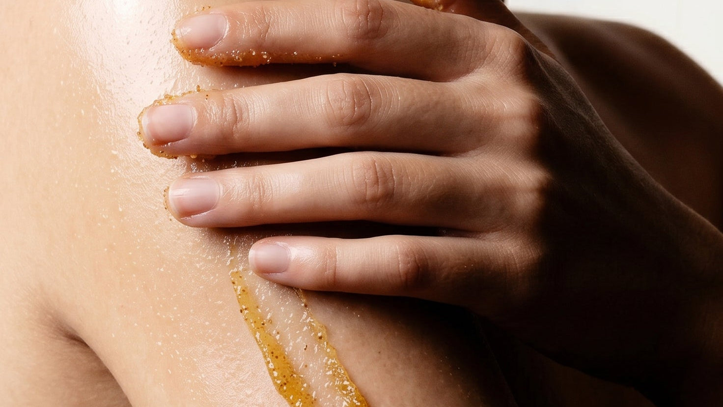 woman applying EXFOLIATING GLOW BODY POLISH to arm