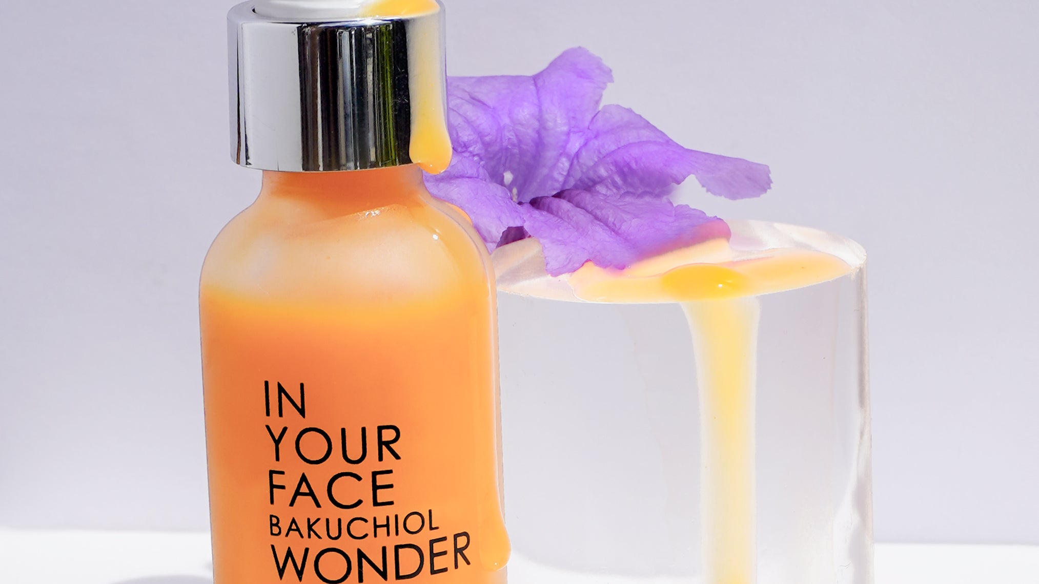BAKUCHIOL WONDER SERIUM next to purple flower