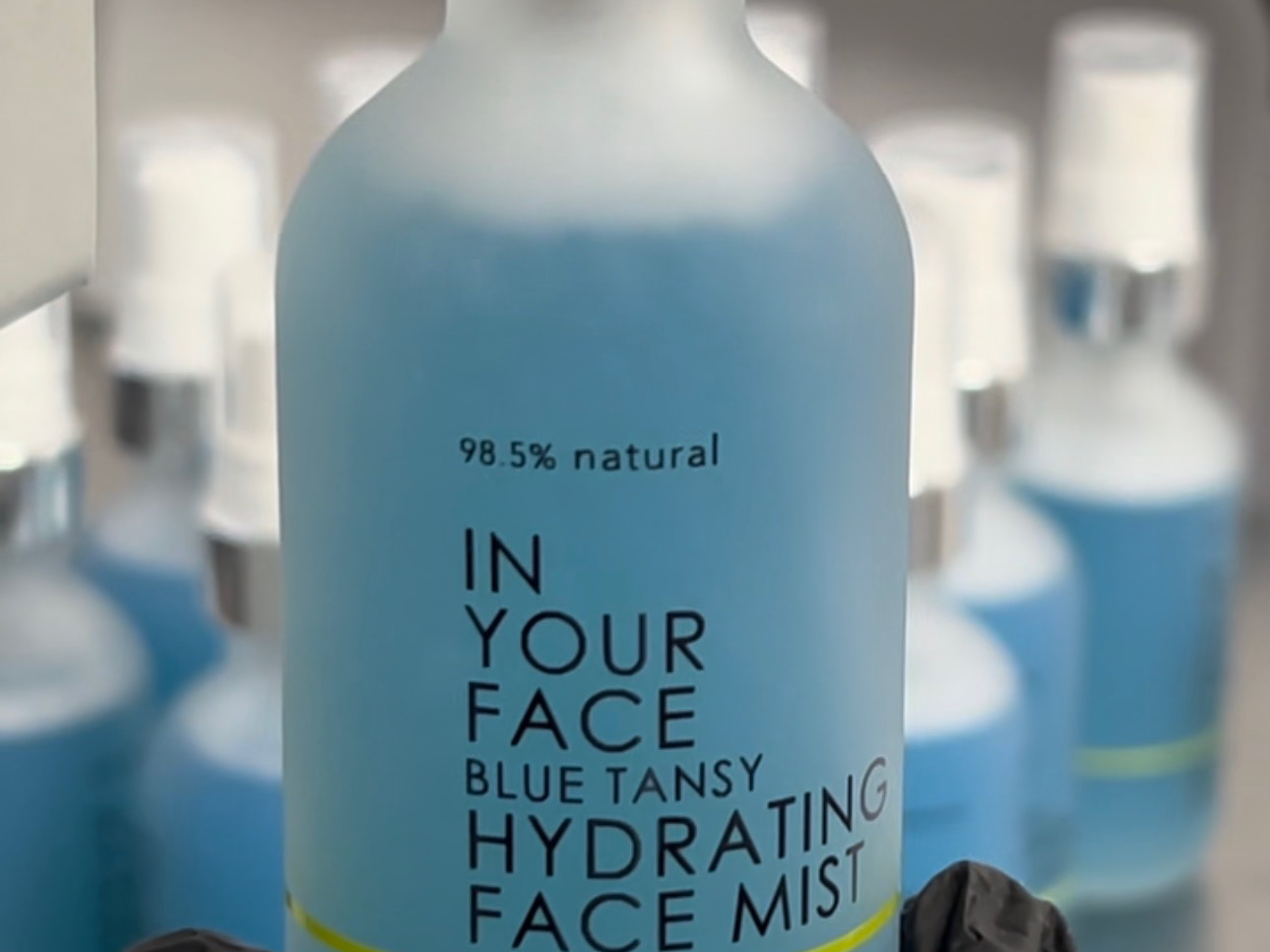 BLUE TANSY HYDRATING FACIAL MIST in gloved hand