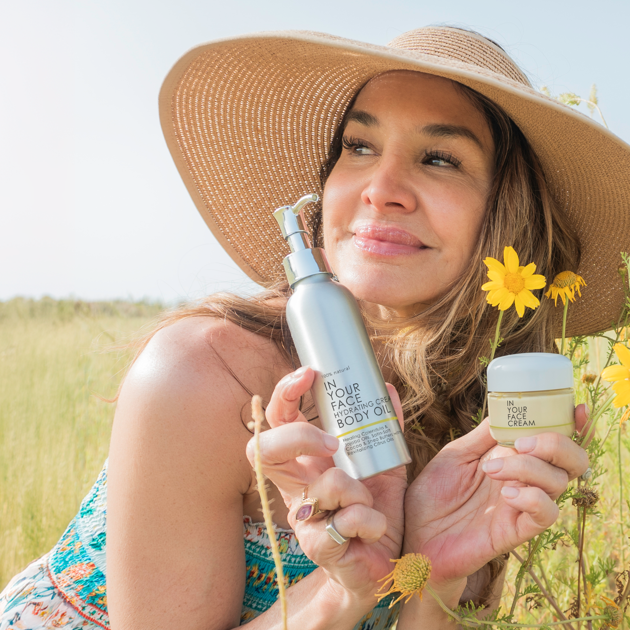 Denice with sun hat in field w/ CREAM & BODY OIL 
