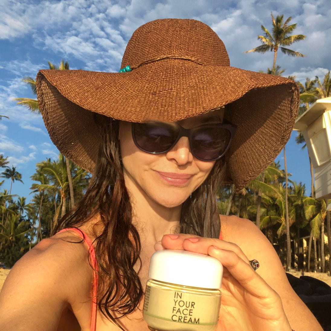 denice duff wearing a hat, holding a jar of IN YOUR FACE CREAM