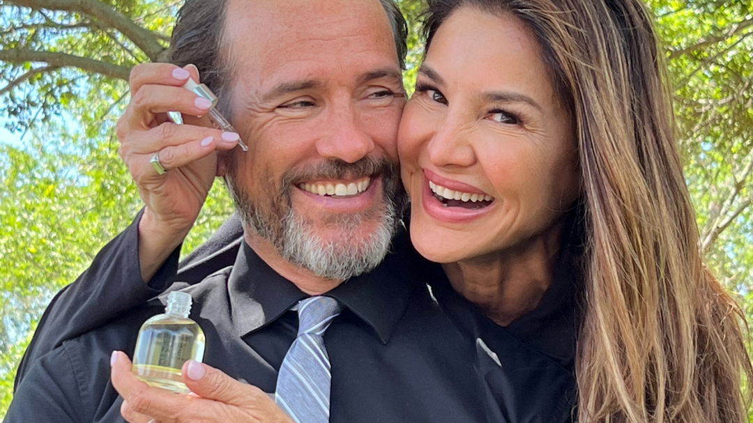 woman and man smiling and hugging, holding OIL