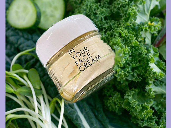IN YOUR FACE CREAM surrounded by healthy greens
