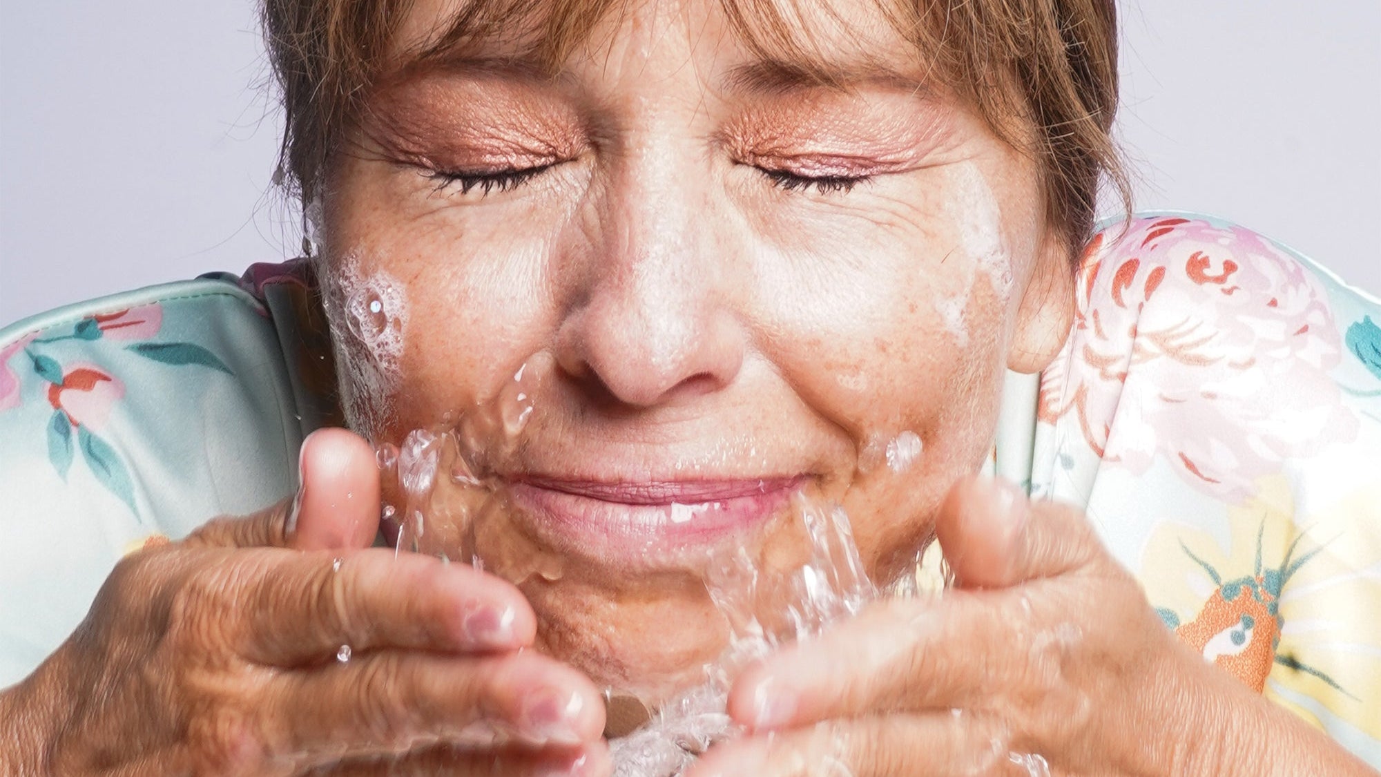 woman splashing water on her face 