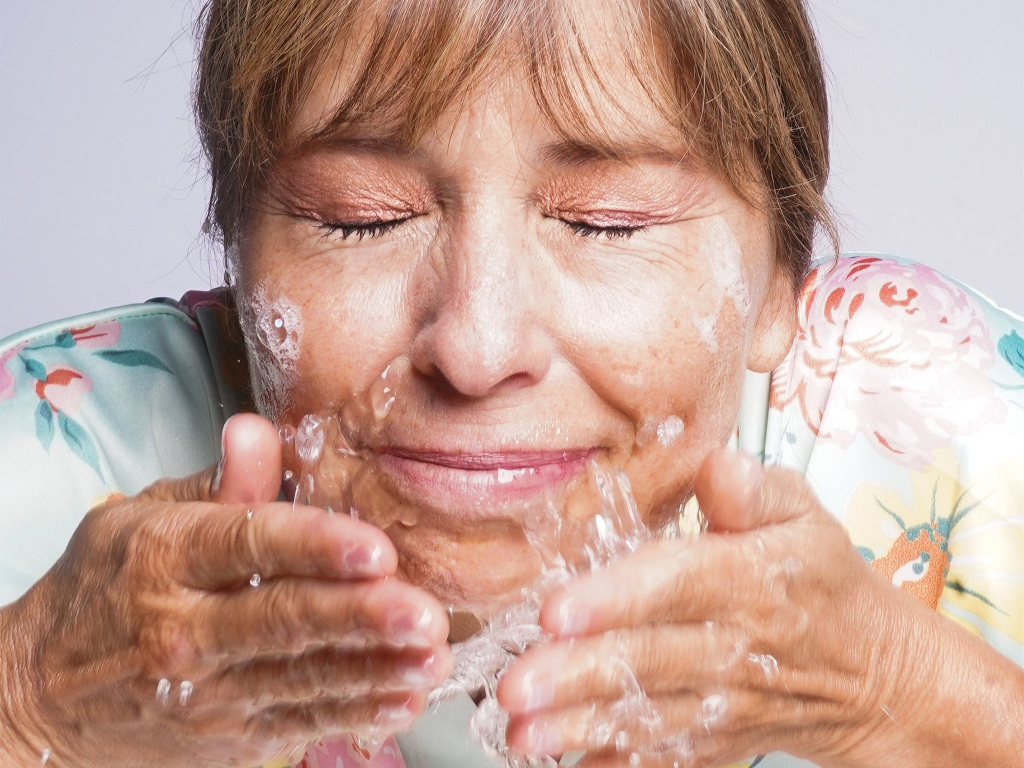 woman splashing water on her face 