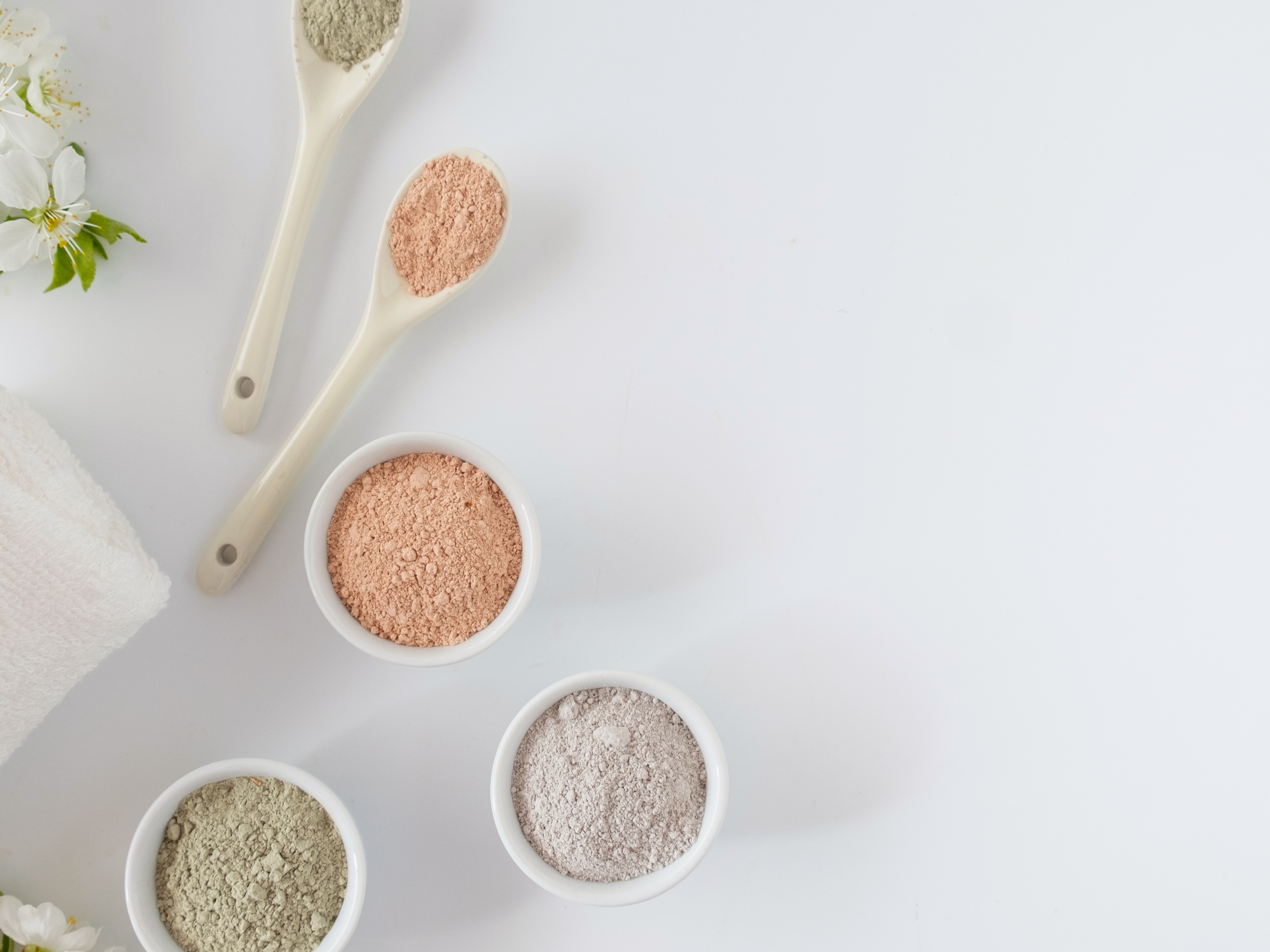 various bowls of colored powder with spoons