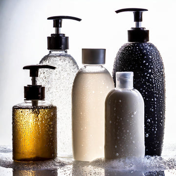 different sized cosmetic bottles on grey background