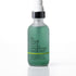 A frosted glass spray bottle of IN YOUR FACE Blue Tansy Hydrating Face Mist, filled with a translucent mint green liquid, featuring a black collar and white spray nozzle, set against a clean white background.