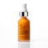A bottle of IN YOUR FACE BAKUCHIOL WONDER SERUM with an orange body, a silver collar, and a white pump dispenser, set against a clean white background with a soft reflection.