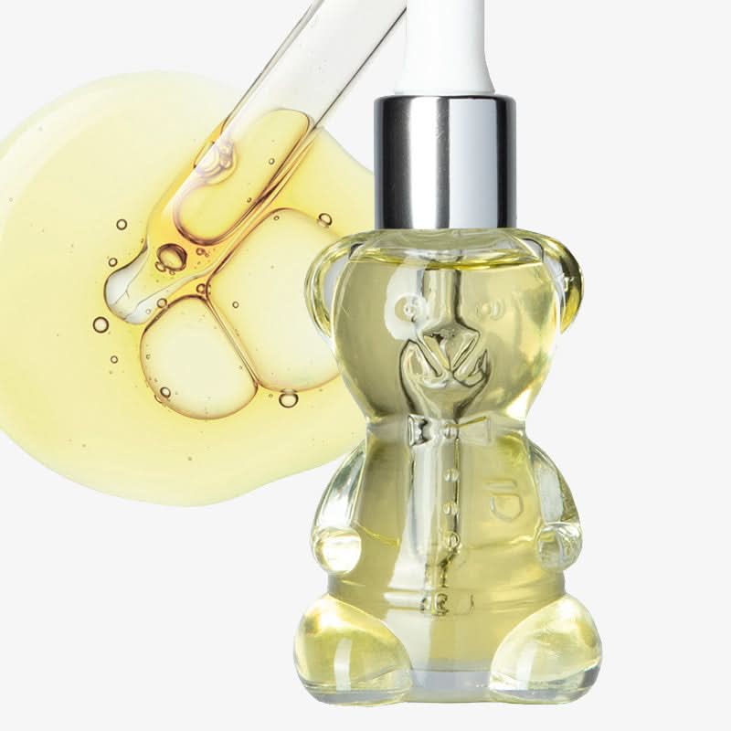 Clear bottle with bear design filled with yellow liquid on a white background