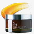 Jar of 'In Your Face Exfoliating Glow Body Polish' with a yellow cream swatch on a white background