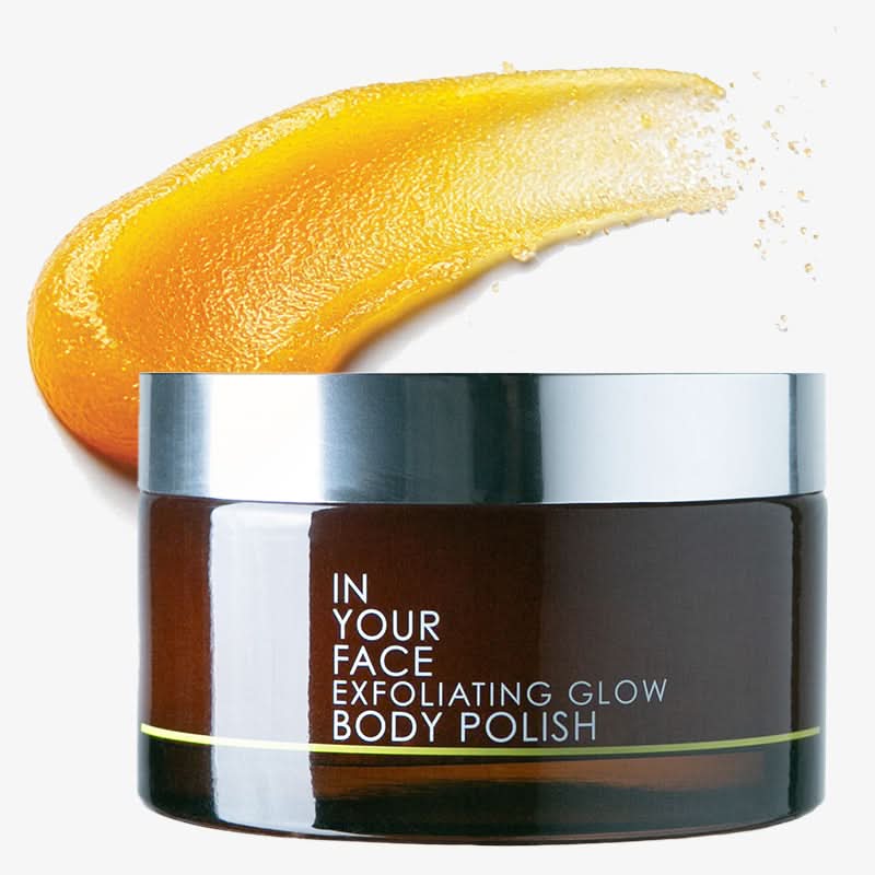 Jar of 'In Your Face Exfoliating Glow Body Polish' with a yellow cream swatch on a white background