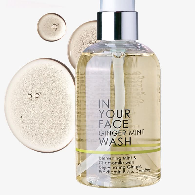 bottle of ginger mint wash with dropplets on white background