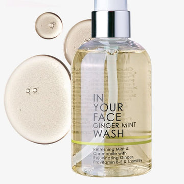 bottle of ginger mint wash with dropplets on white background