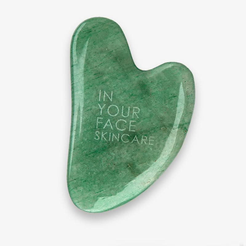 Green stone gua sha tool with 'In Your Face Skincare' text on a white background