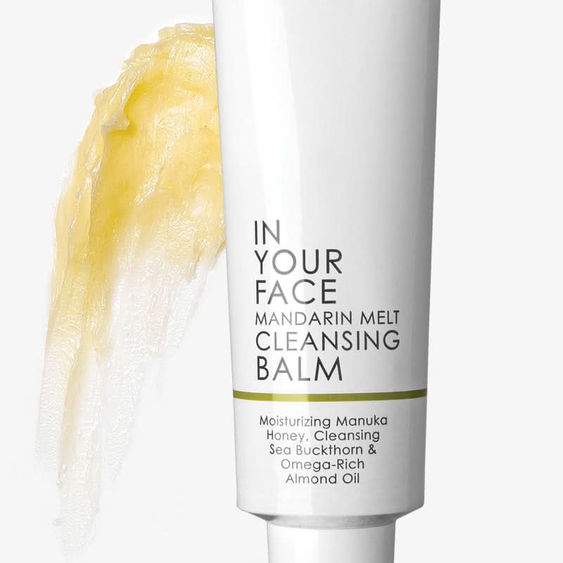 Cleansing balm tube with yellow cream on a white background