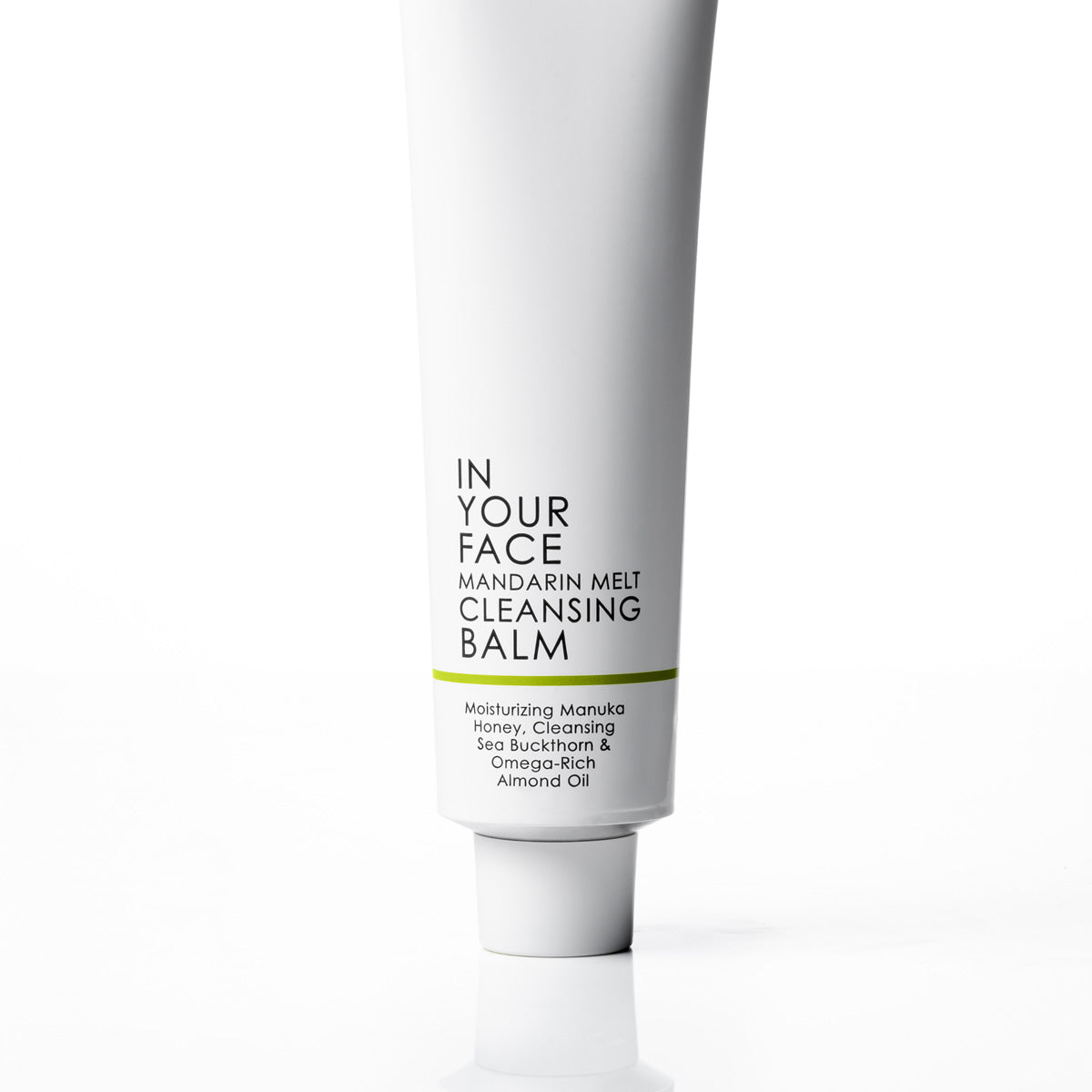 A white squeeze tube of 'In Your Face Mandarin Melt Cleansing Balm' on a clean white background with a soft reflection underneath.