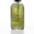 A clear glass bottle of face moisturizing wash filled with greenish-yellow liquid and visible bubbles, with a black dropper cap and black text reading 'IN YOUR FACE MOISTURIZING WASH' on a white background.