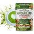 ReviTEalize Matcha Blend with Mushrooms & Turmeric in a green and white stand-up pouch, shown next to a white cup of matcha latte with heart-shaped foam art and green powder splashes on a white background.