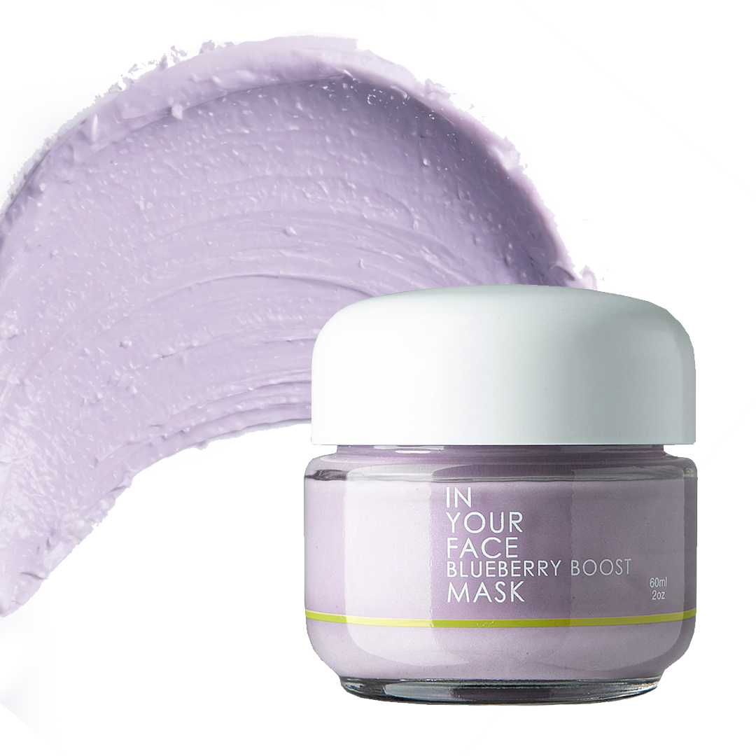 a jar of the IN YOUR FACE BLUEBERRY BOOST MASK on a white background. A light lilac-colored product with a white lid. A smear is next to the jar showing a fluffy, creamy texture of the mask.