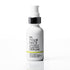 A white pump bottle of 'In Your Face Vitamin C Plumping Serum' with a black collar and a thin yellow accent line on the label, set against a clean white background with a soft reflection below.