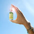 moisturizing wash mini held in blue sky with light flare