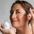 woman applying peptide serum to face with dropper