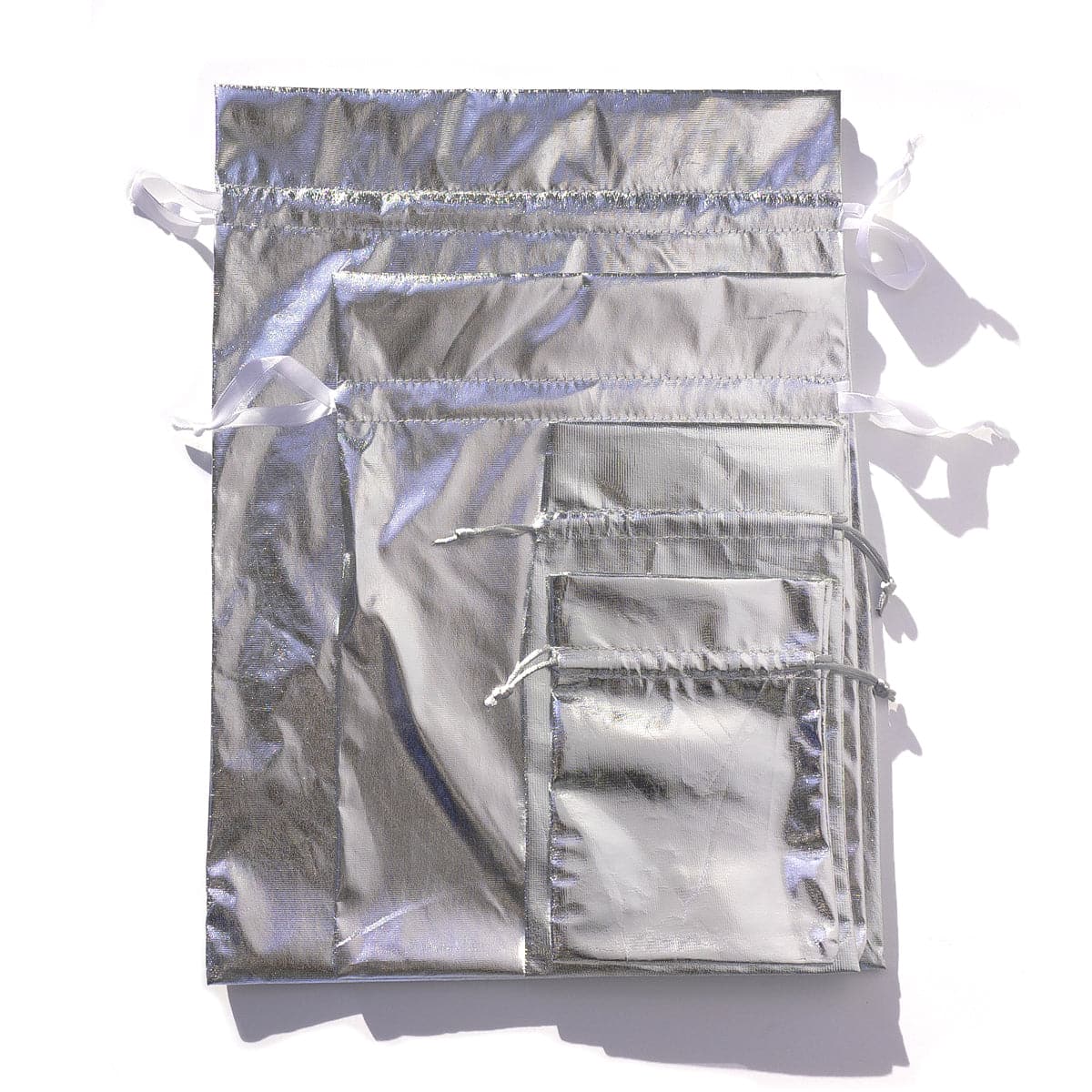 4 metallic silver drawstring gift bags on white background