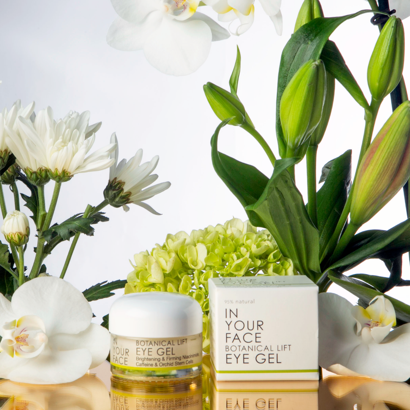 a beautiful image of the EYE GEL next to some white flowers and botanicals.